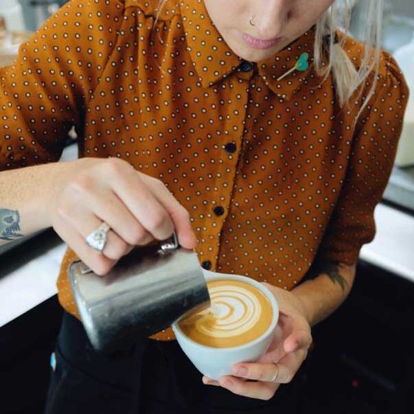 tattooed girl pouring latte art small